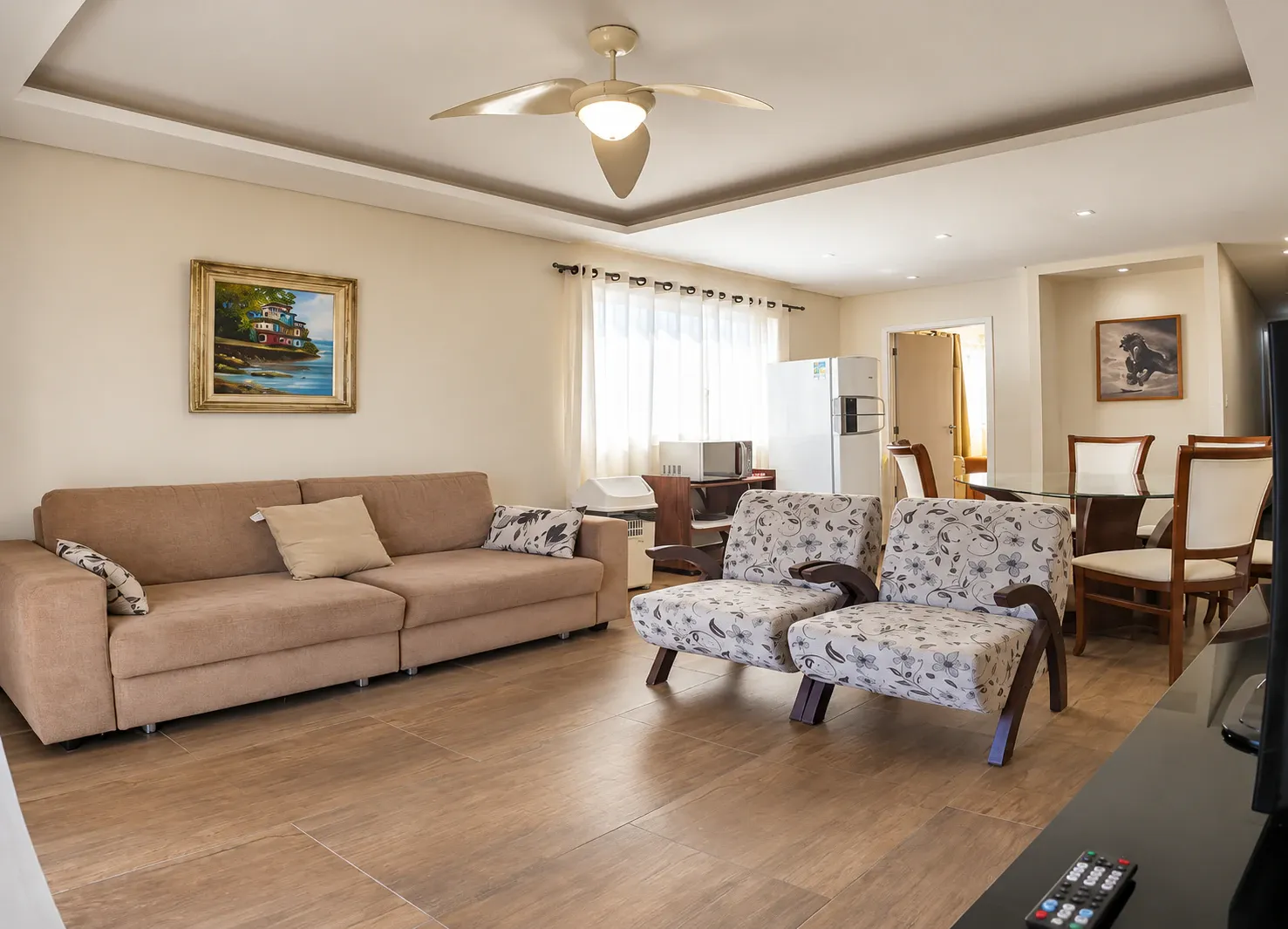 Sala do Apartamento de 2 Quartos com sofá, poltronas, mesa de jantar e área para lanche