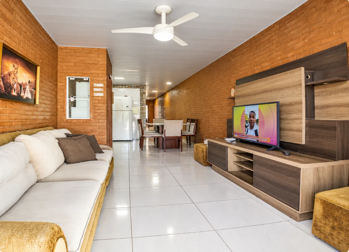 Sala da Casa de 4 Quartos com sofá, televisão e mesa de jantar integrada à cozinha