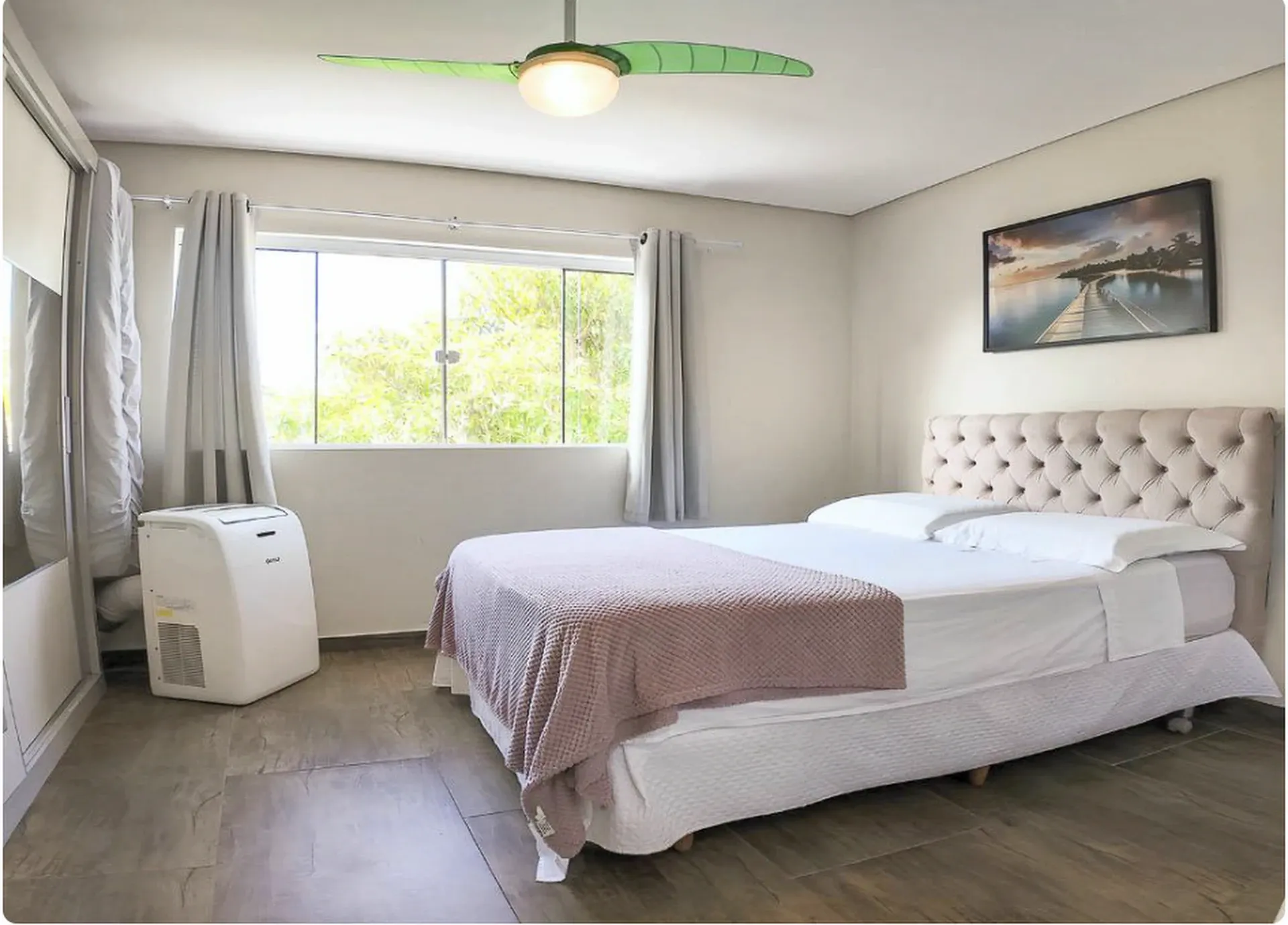 Quarto com cama de casal, janela ampla, armário espelhado e ventilador de teto